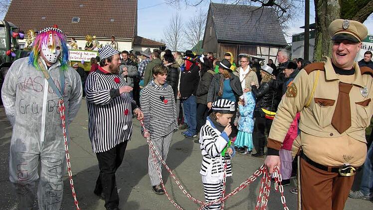 Fest im Griff: Bürgermeister Michael Keilich führte als Ortssheriff eine Gruppe "gefangener Ortsteile" an der langen Kette vor.