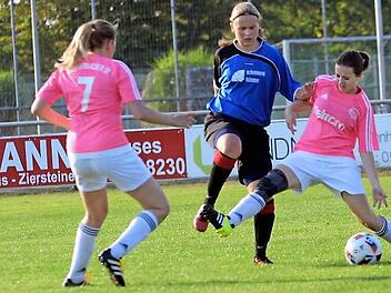Die Eggolsheimerin Lena Amon (M.) wird von zwei Hammerbacherinnen attackiert, doch die doppelte Manndeckung nutzte nichts: Die DJKlerin legte zum Auftakt in die Kreisliga zwei Treffer auf und traf noch selbst zum 3:1-Endstand.  Foto: herzopress