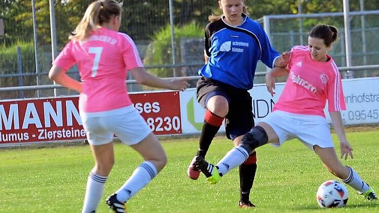 Die Eggolsheimerin Lena Amon (M.) wird von zwei Hammerbacherinnen attackiert, doch die doppelte Manndeckung nutzte nichts: Die DJKlerin legte zum Auftakt in die Kreisliga zwei Treffer auf und traf noch selbst zum 3:1-Endstand.  Foto: herzopress