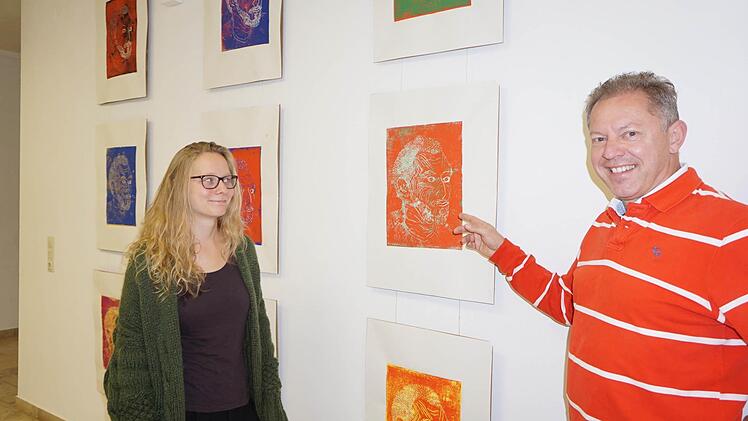 Rebekka Barth (im Bild mit Martin Bühner) zeigt ihre Portraitserie im Foyer der Holzbilderhauerschule in Bischofsheim.  Foto: Marion Eckert