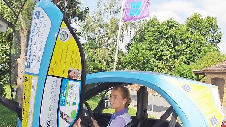 Julia Kania, die Pflegedienstleiterin der Diakoniestation Küps, hat viel Spaß beim Fahren des Elektro-Einsatzfahrzeugs.  Foto: hs