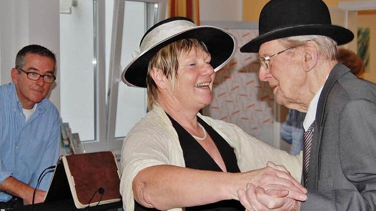 Erich Weber (98) eröffnete als ältester Gast des Bad Bockleter Tagespflegeheims mit Geronto-Fachkraft Monika Ziegler die Ü70-Party im Bockleter "Seniorenheim am Saaleufer"; im Hintergrund des Bildes der Würzburger DJ Erwin Pirger.  Foto: Sigismund von Dobschütz