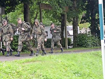 Jeder hat seine Aufgabe und Arbeit beim Reservisten-Biwak. Während die eine Gruppe den sechs Kilometer langen Marsch mit Sturmgepäck zurücklegt, sorgt ein anderer Reservist (r.) für Holz für das Lagerfeuer. Foto: eh