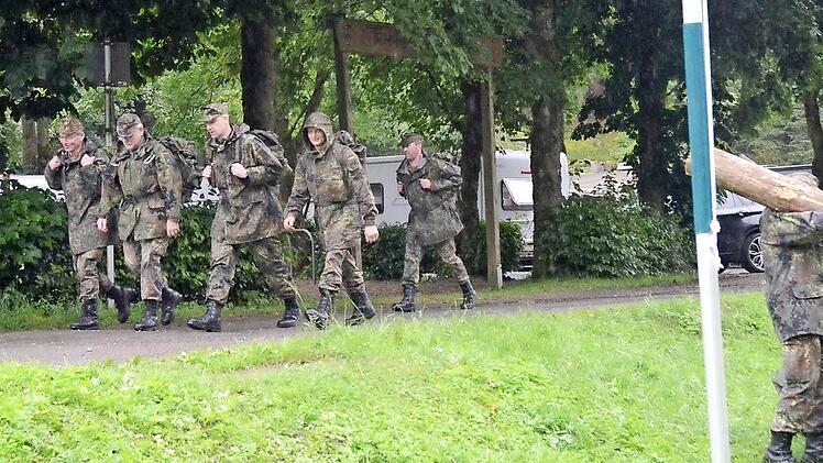Jeder hat seine Aufgabe und Arbeit beim Reservisten-Biwak. Während die eine Gruppe den sechs Kilometer langen Marsch mit Sturmgepäck zurücklegt, sorgt ein anderer Reservist (r.) für Holz für das Lagerfeuer. Foto: eh