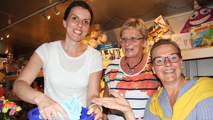Kunigunde Brandt (Mitte) und zwei von vielen ehrenamtlichen Helfern verkaufen die Lose. Wer den Berg wirklich kennt, macht am Glückshafen halt. Foto: Michael Busch