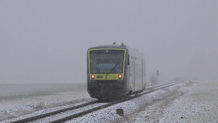 Ein Zug kommt aus dem Nebel.