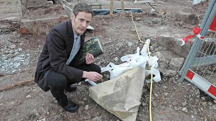 Eine alte Grabsteinplatte bedeckte den Brunnen. Sie ging bei den Baggerarbeiten zu Bruch. Pfarrer Peter Bauer forscht nun nach den Ursprüngen des alten Brunnens. Foto: Gerhard Schmidt