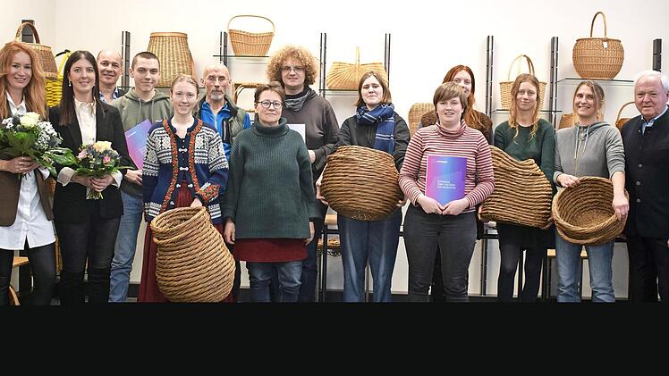 Die Abschlussklasse mit dem stellvertretenden Landrat Helmut Fischer (r.) zeigen ihre Zertifikate und einige Exponate.