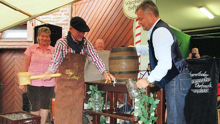 "O'zapft is". Bürgermeister Karlheinz Kickuth (l.) und Bernhard Roth (r.) stechen das Freibier an. Foto: Winfried Ehling