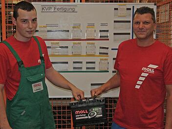 Kenneth Bonsell und Michael Schubert, Mitarbeiter in der Fertigung, präsentieren eine neue EFB-Batterie. Foto:  Bastian Girg