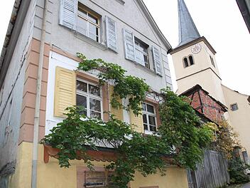 Die meisten Kirchenbesucher haben sich seit Jahren an den Anblick gewöhnt, mit der Zwangsversteigerung des Anwesens Eichstraße 2 mitten in Sulzthal kommt nun Bewegung in die Sache. Die Investorin kündigte an, das Haupthaus (links) erhalten zu wollen. Fotos: Ralf Ruppert