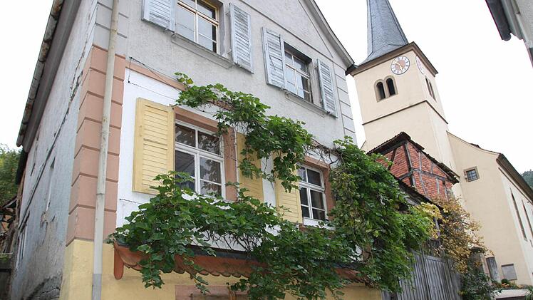 Die meisten Kirchenbesucher haben sich seit Jahren an den Anblick gewöhnt, mit der Zwangsversteigerung des Anwesens Eichstraße 2 mitten in Sulzthal kommt nun Bewegung in die Sache. Die Investorin kündigte an, das Haupthaus (links) erhalten zu wollen. Fotos: Ralf Ruppert