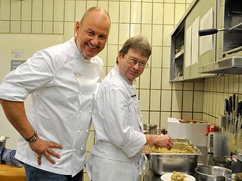 Frank Rosin schaut dem Neuen am Herd über die Schulter: Küchenchef Peter Herberer formt Semmelknödel.  Foto: Regina Vossenkaul