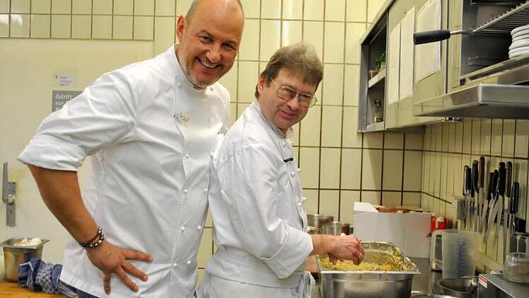 Frank Rosin schaut dem Neuen am Herd über die Schulter: Küchenchef Peter Herberer formt Semmelknödel.  Foto: Regina Vossenkaul
