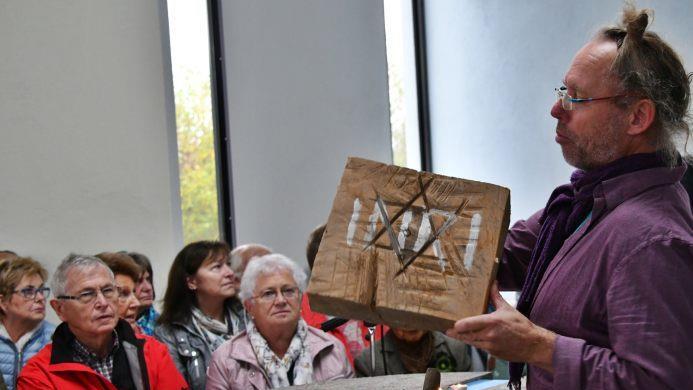 Der Künstler Gernot Ehrsam hatte einen Holzblock mitgebracht, den er künstlerisch gestaltet hatte. Man erkannte den Davidstern und die Inschrift "I N R I", wie sie am Kreuz Christi angebracht war. Foto: Hanns Friedrich