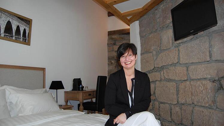 Historisches Mauerwerk inklusive: Stefanie Weppler, die Leiterin des neuen Hotels, in einem der vielleicht schönsten Zimmer. Fotos: Oliver Schmidt