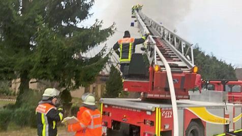 Die Feuerwehr löscht von der Drehleiter aus.