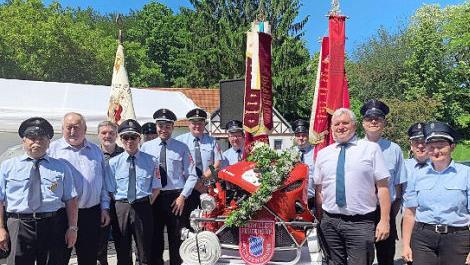 Die Geistlichkeit, Pater Rudolf Theiler und Pfarrer Bernd Grosser (Zweiter und Dritter von links), Bürgermeister Jürgen Hennemann (Vierter von rechts) und die Feuerwehrleute aus Weißenbrunn strahlen vor der neuen Tragkraftspritze mit der Sonne um die Wette.  Foto: Carolin Dittmann