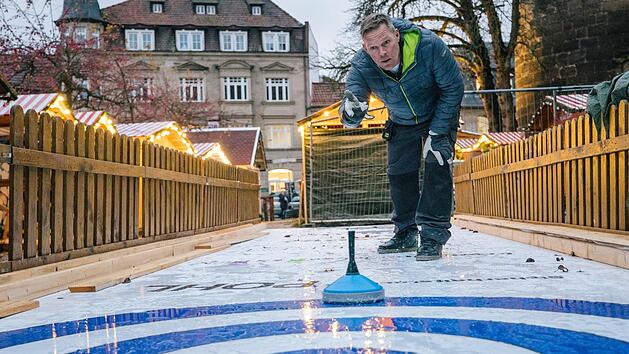 Eine rutschige Angelegenheit: Steffen Mahr vom ausrichtenden Verein "Kronacherleben" hat die Eisstockschie&szlig;en-Anlage bereits eingeweiht. Sie soll nicht nur f&uuml;r Kinder die neue Attraktion des Kronacher Weihnachtsmarkts werden. Foto: Marian Hamacher