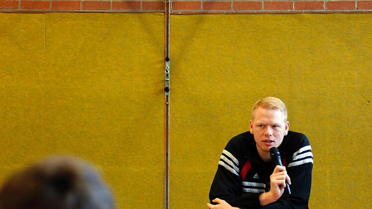 Passender Ort - in der Sporthalle unter dem Basketballkorb beantwortet Neumann die Fragen.