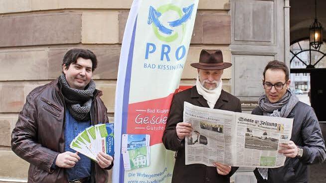 Werbegemeinschaftsvorsitzender Heiko Grom (links) mit der Gutschein-Mappe, an der sich auch die Saale-Zeitung beteiligt, wie OB Kay Blankenburg und der stellvertretende Vorsitzende von Pro Bad Kissingen, Michael Pal, beweisen. Foto: Thomas Mäuser