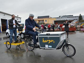 Bürgermeister German Hacker chauffiert das Lastenrad, mit Christian Stöcker als "Ballast" auf dem Anhänger.  Foto: Bernhard Panzer
