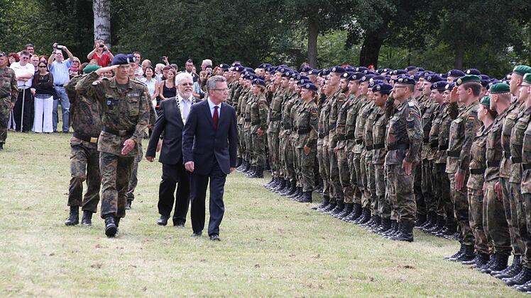 Minister Thomas de Maizière, Bürgermeister Wolfgang Back und Oberstleutnant Frank Moritz (von rechts) beim Abschreiten der Front.