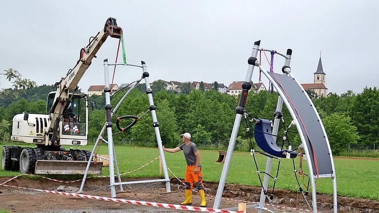 Zwei Mitarbeiter des gemeindlichen Bauhofs sind hier bei der Stellprobe des neuen Klettergerüstes. Sie hatten bereits eine entsprechende Grube auf dem Außengelände der Grundschule Premich ausgehoben und wollten die Fundamente anlegen. Doch daraus wurde vorerst nichts. Foto: Kathrin Kupka-Hahn