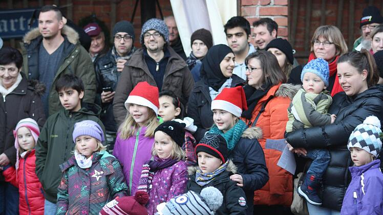 Alle Kinder, die deutschen und die aus anderen Ländern lauschten andächtig, dem Nikolaus. Im Hintergrund einige der "Neu-Zeitlofser" mit ihrer Betreuerin Christa Zeller-Niebuhr (im orangen Anorak). Foto: Joachim Weichert