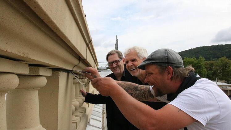 Otto Gass (von links) und Erwin Full vom Staatlichen Bauamt schauen auf dem Dach Steinmetz Steven Müller beim Verfugen der Balustraden auf dem Luitpoldbad über die Schulter. Fotos: Ralf Ruppert
