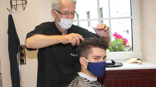 Friseur Thomas Ploner kommt seinen Kunden - hier Yannik Zenker - ganz nah, deshalb ist es wichtig, dass sich jeder an die Maskenpflicht h&auml;lt.