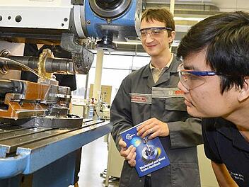 Man Nguyen (rechts) betrachtet im Bosch-Ausbildungszentrum Bamberg eine Fräsmaschine.  Künftig soll er in seiner Heimat Vietnam als Bosch-Ausbildungsmeister junge Menschen betreuen.  Vorbild ist dabei der Bamberger Ausbildungsmeister Mario Fischer (links). Foto: R.  Rinklef