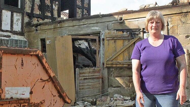 Beate Gürtler steht im Garten vor ihrem ehemaligen Wohnhaus. Der Brand vor zweieinhalb Wochen zerstörte das Zuhause ihrer Familie. Sie suchen nun eine neue Bleibe.  Fotos: Vanessa Schneider