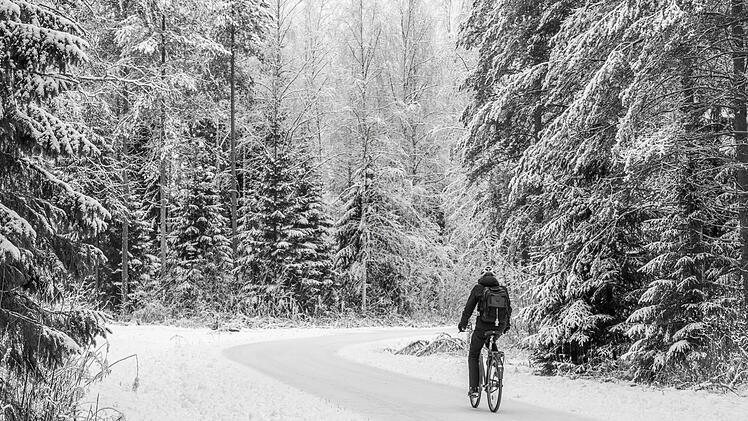 Beautiful winter snowy landscape with a cyclist. Oulu has an excellent cycling infrastructure, the best in Finland. People ride bicycles in all seasons. Oulu is the European Capital of Culture 2026.