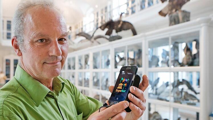 Museumsleiter Matthias Mäuser mit dem Smartphone im Vogelsaal, der "didaktisch lange Brachland war", weil die Optik des unter Denkmalschutz stehenden Saals nicht mit Erklärungstafeln beeinträchtigt werden konnte.  Foto: Matthias Hoch
