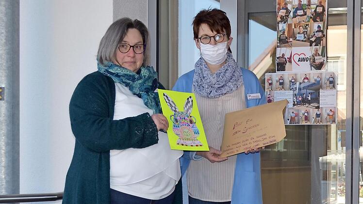 Religionslehrerin Veronika Fath (links) überreicht einen Umschlag mit Schülerbildern an Christine Wicke von der Awo. Foto: Thomas Micheel
