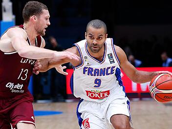 Der in Diensten der Brose Baskets Bamberg stehende Janis Strelnieks (links) stand klar im Schatten von Frankreichs Superstar Tony Parker, der trotz schwacher Wurfquote (29 Prozent) 18 Punkte (6 Assists) erzielte. Der lettische Spielmacher kam auf 14 Punkte und sieben Assists. Foto: Sebastian Nogier/dpa