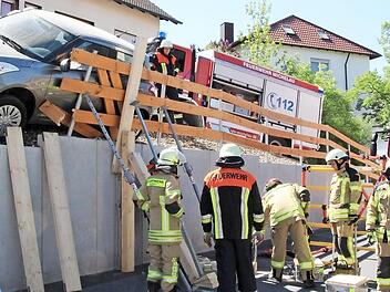 Die örtlichen Feuerwehren musste das abgerutschte Auto schnell von oben und unten stützen, damit es nicht weiter kippte.  Fotos: Jutta Rudel