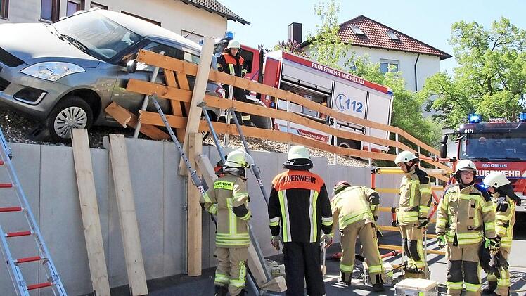 Die örtlichen Feuerwehren musste das abgerutschte Auto schnell von oben und unten stützen, damit es nicht weiter kippte.  Fotos: Jutta Rudel