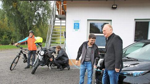Während Bürgermeister Helmut Blank (rechts) und Andreas Schlembach ein Auto anschließen, nutzen Martin Geßner (links) die Tankstelle für sein E-Bike und Matthias Geßner für sein Motorrad.  Foto: Thomas Malz