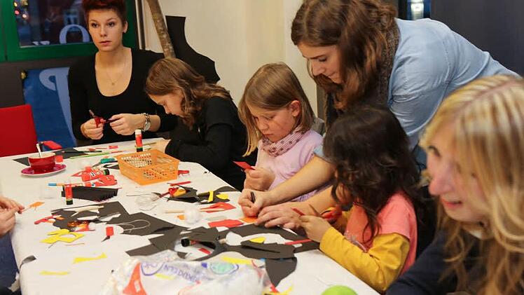 Sara Lüttich (stehend) hilft den Kindern beim Basteln in der Stadtbücherei. Foto: Barbara Herbst