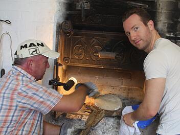 Im Dorfbackofen des Alten Rathauses: Hubert und Johannes Warmuth. Auf Kundschaft müssen die "Dorfbäcker" nicht lange warten. Die ofenfrischen Bauernlaibe sind schnell ausverkauft.  Foto: Werner Vogel