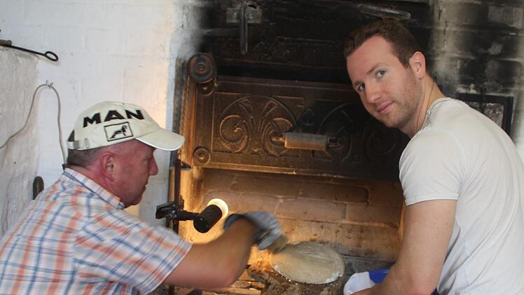 Im Dorfbackofen des Alten Rathauses: Hubert und Johannes Warmuth. Auf Kundschaft müssen die "Dorfbäcker" nicht lange warten. Die ofenfrischen Bauernlaibe sind schnell ausverkauft.  Foto: Werner Vogel