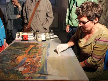 Heike Günther beim Reinigen des Ölgemäldes Foto: Franziska Knobloch