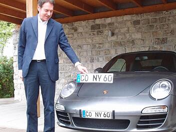 Am Porsche befindet sich das Klebekennzeichen, Michael Stoschek hält das Original-Kennzeichen in der Hand: Im August, kurz nachdem er den Strafbefehl erhalten hatte, demonstrierte der Unternehmer den Vergleich. Foto: CT-Archiv/Jochen Berger