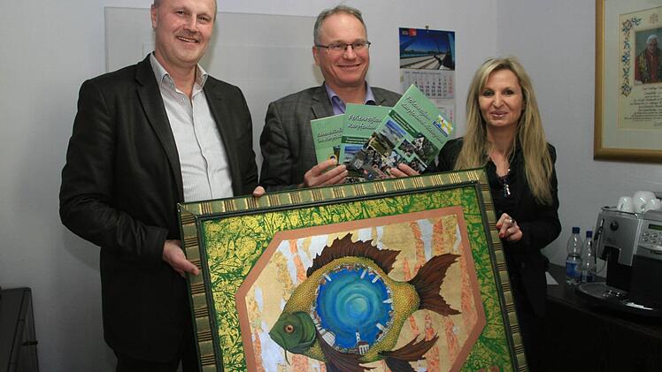 Gerald Brehm, Martin Oberle und Sandra Hammer (v. l.) mögen den Karpfen in jeder Form, auch wenn er nur gemalt ist. Foto: Sylvia Hubele