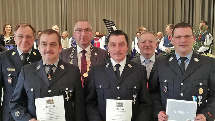 Die Feuerwehrmänner Rainer Wehner (Roth; vorne von links) und Stefan Schmitt (Hohn) wurden für ihre 40-jährige Dienstzeit vom Freistaat Bayern mit dem Ehrenzeichen ausgezeichnet, Christian Horn (Bad Bocklet) erhielt für seine 20-jährige Amtszeit als Kommandant das silberne Ehrenkreuz des Deutschen Feuerwehrverbandes. Foto: Sigismund von Dobschütz