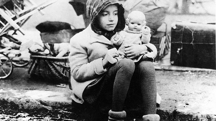 Sie registriert den Fotografen und ist doch in ihre Gedankenwelt versunken. Was mag dieses Flüchtlingsmädchen alles erlebt haben? Das von der Deutschen Presseagentur veröffentlichte Archiv-Foto der US-Army wurde gegen Ende des Zweiten Weltkriegs aufgenommen.