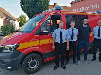 Kommandant Manuel Gessner (links) und Vorsitzender Dominik Bieber (rechts) mit Nick Wehner (2. v.l.) und Tobias Sauer (2.v.r.) vor dem neuen Mehrzweckfahrzeug.