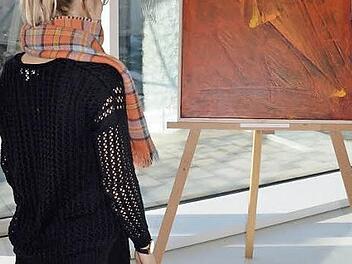 Eine Ausstellungsbesucherin betrachtet das Bild von Dennis Wolter mit dem Titel "Lichtwirbel". Foto: Andrea Spörlein